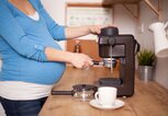 Schwangere Frau bereitet einen Kaffee zu | © iStock.com | M_a_y_a