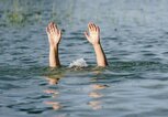 Hände ragen aus dem Wasser, um eine ertrinkende Person darzustellen | © iStock.com / kulkann