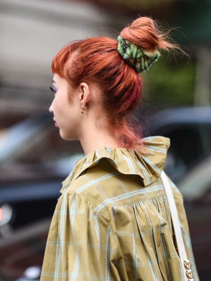 Frau mit roten Haaren und hohem Dutt von hinten  | ©  gettyimages.de | Daniel Zuchnik
